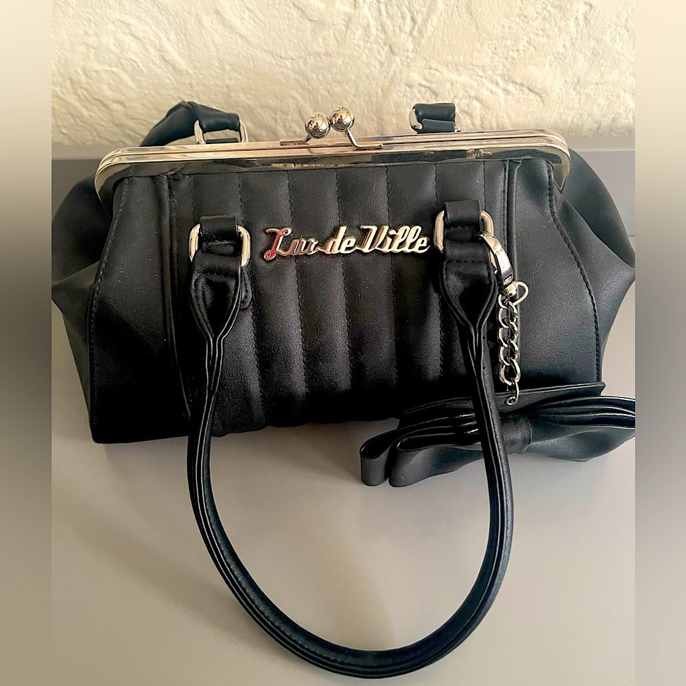 Lux de Ville black snap closure bag with bow attachment